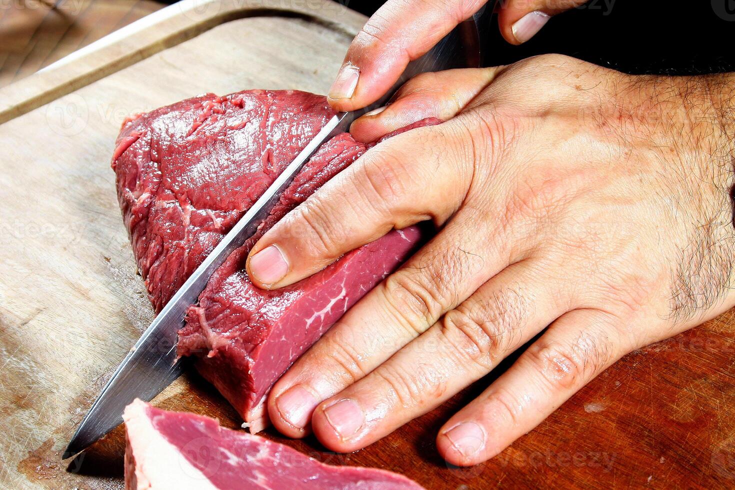 professional butcher teaching step by step how to prepare picanha, a Brazilian cut of meat photo