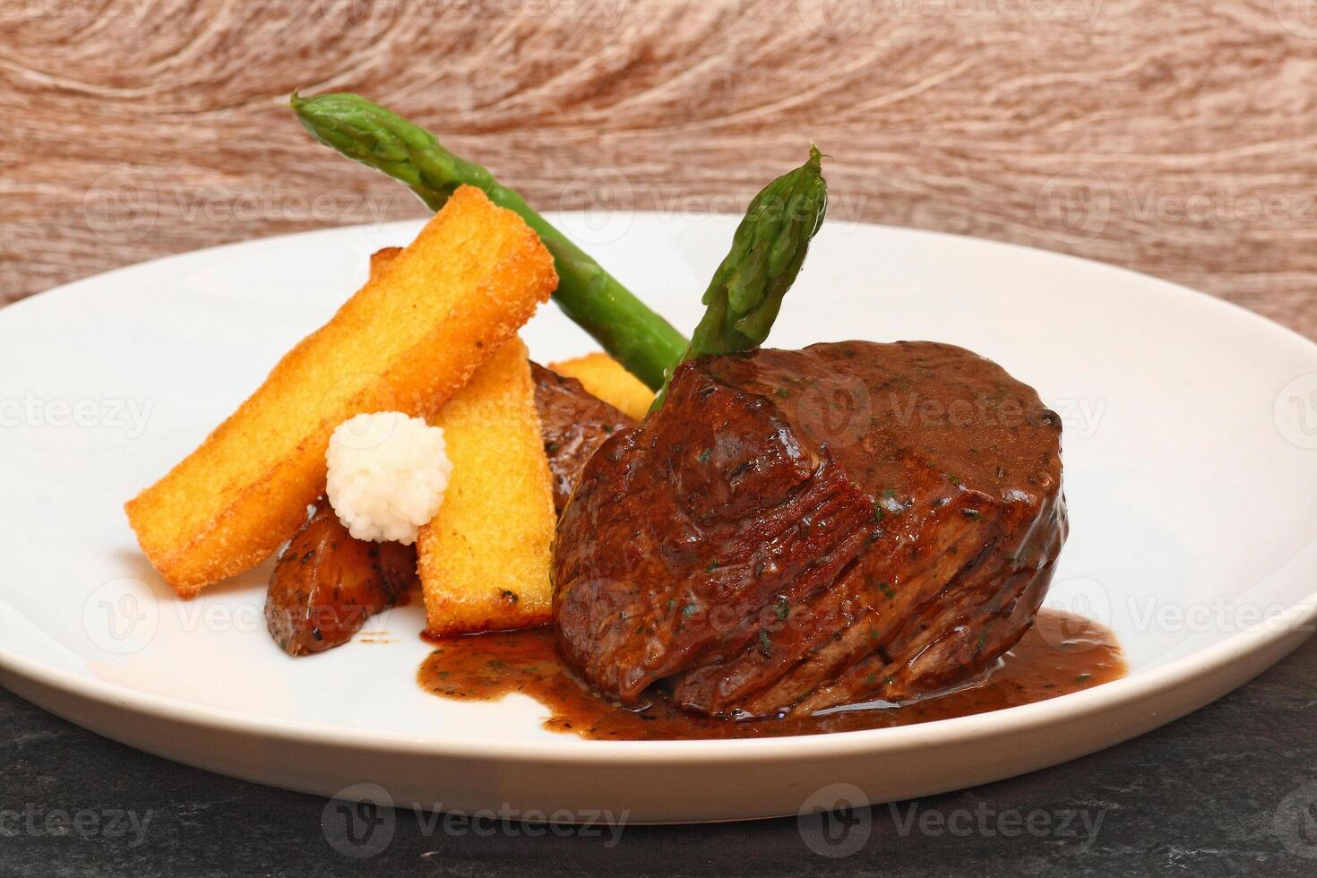 fillet in Madeira sauce with asparagus on plate photo