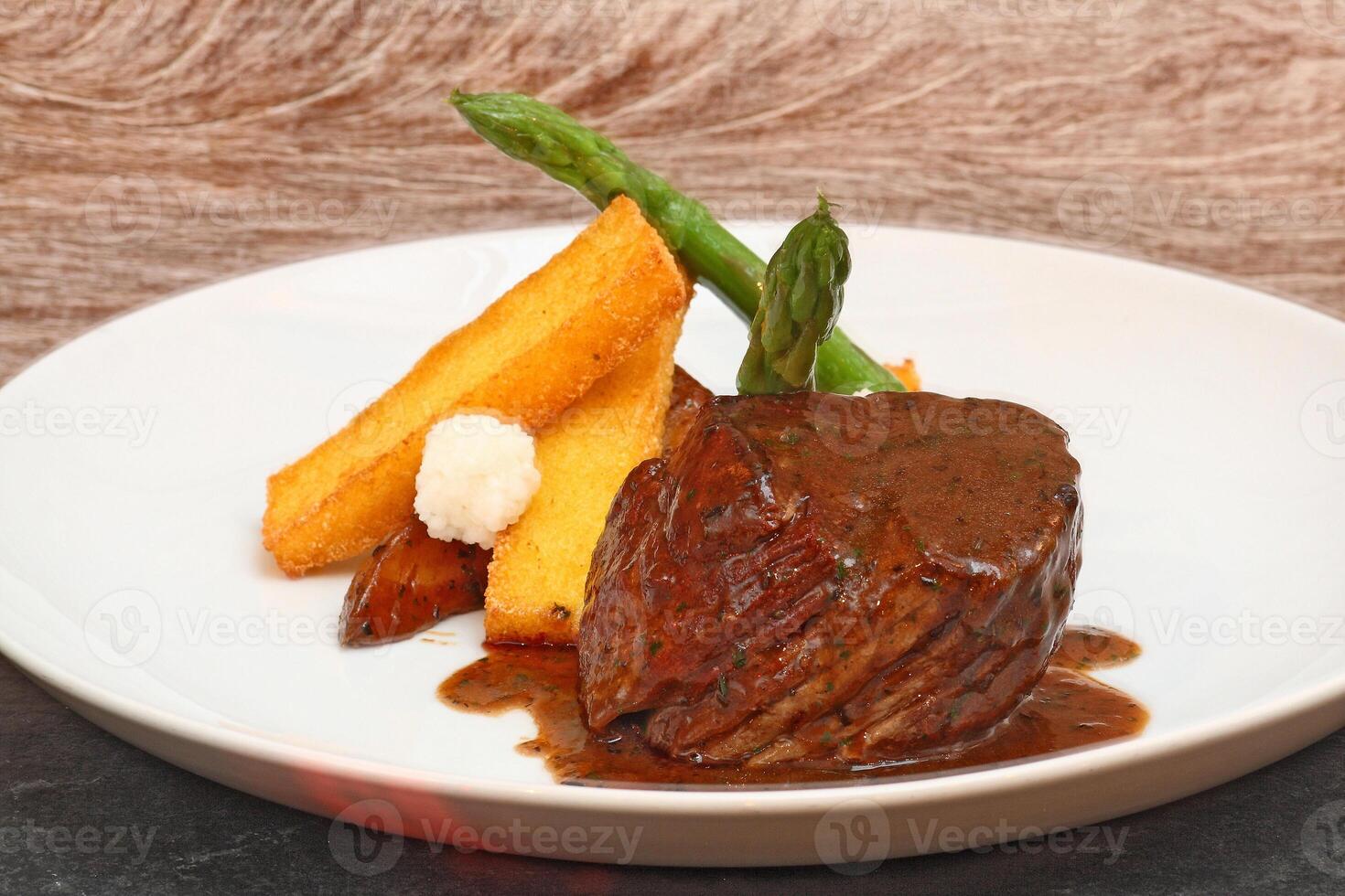 fillet in Madeira sauce with asparagus on plate photo