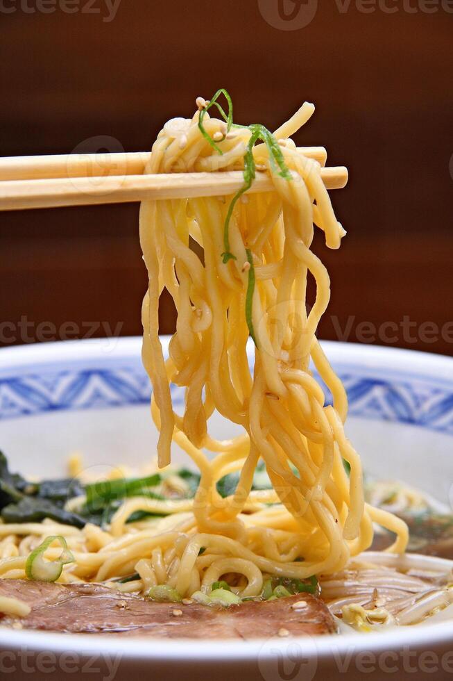 Japanese ramen, soup mix with noodles, meat, eggs and vegetables photo
