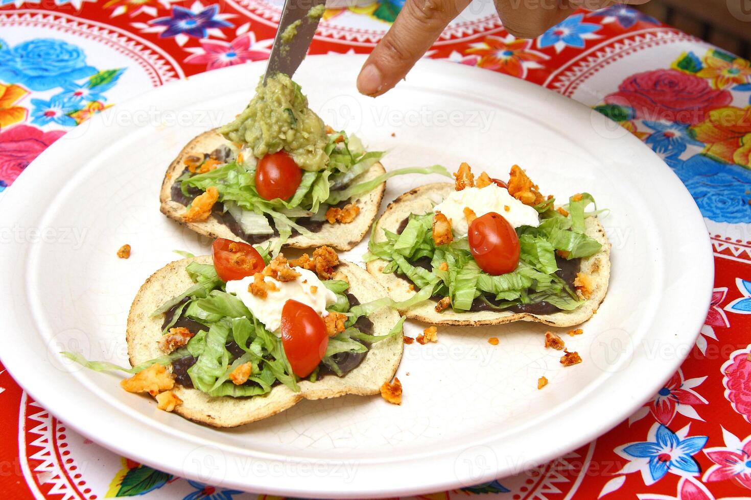 tradicional Tostada, clásico de mexicano cocina con lechuga, Cortado Tomates, frito pollo papas fritas foto