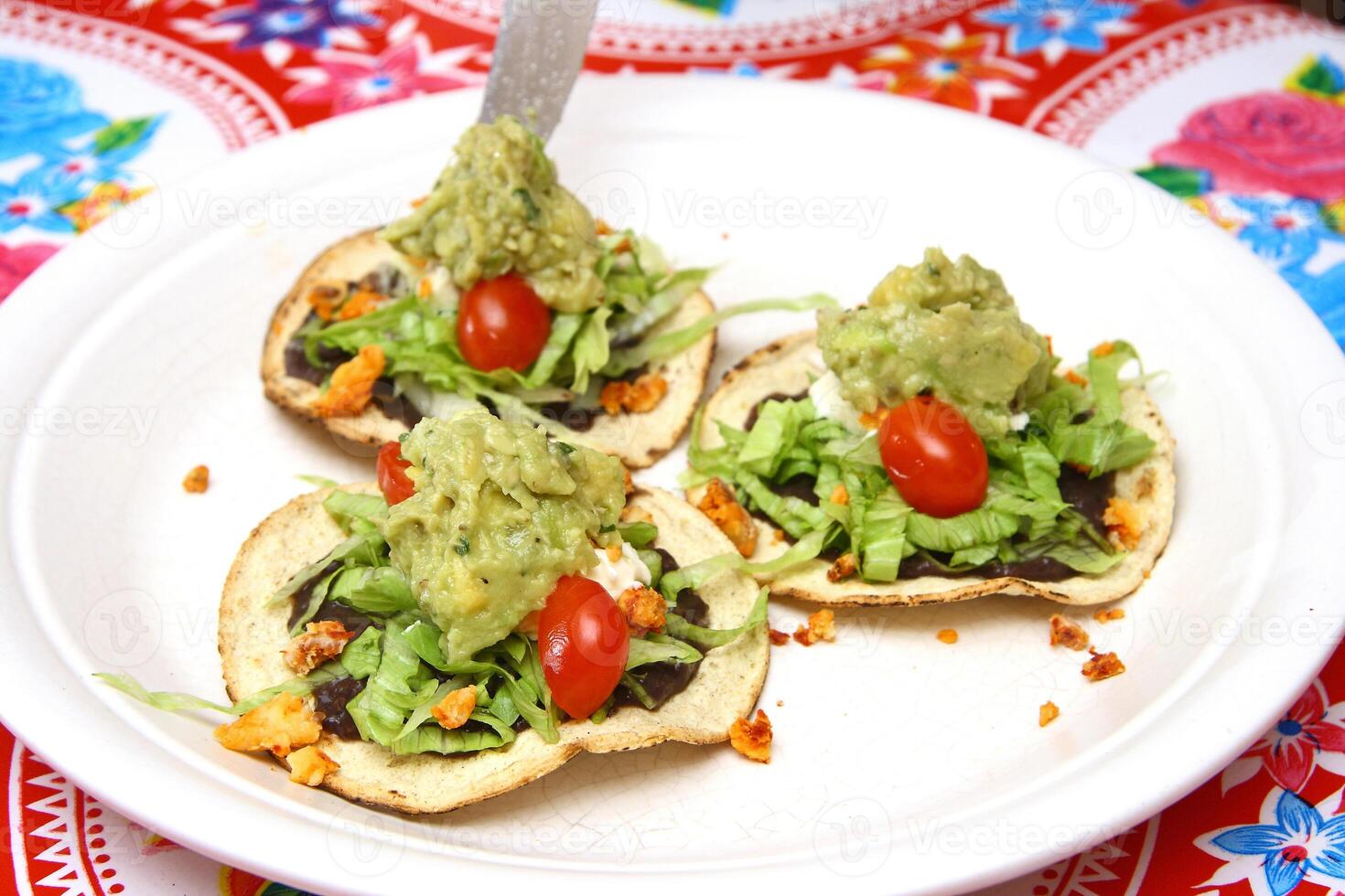 tradicional Tostada, clásico de mexicano cocina con lechuga, Cortado Tomates, frito pollo papas fritas foto