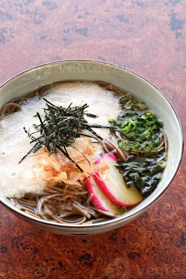 Soba, classic Japanese cuisine, with soba or udon noodles, egg, ginger, pork loin and green onions photo