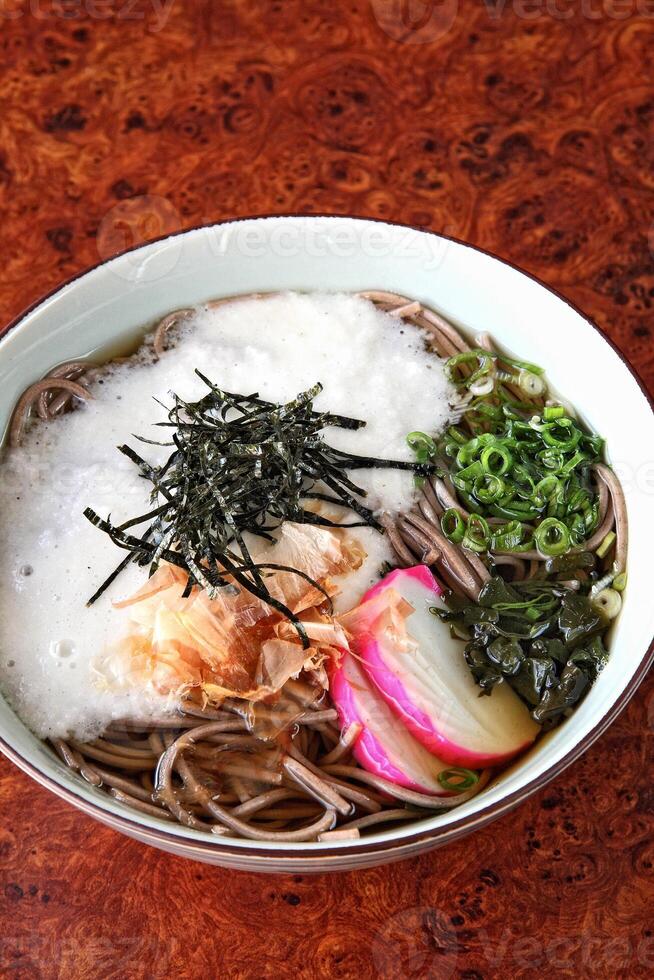 Soba, classic Japanese cuisine, with soba or udon noodles, egg, ginger, pork loin and green onions photo