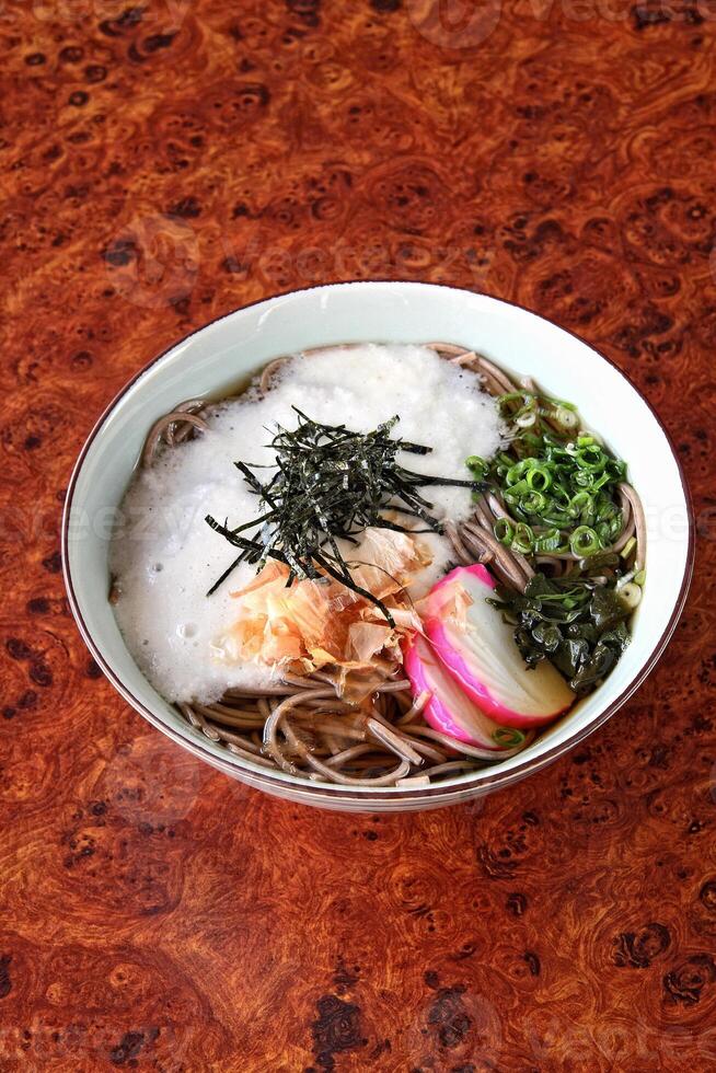 Soba, classic Japanese cuisine, with soba or udon noodles, egg, ginger, pork loin and green onions photo