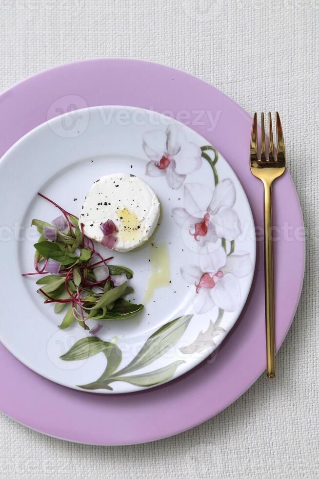 brie cheese and salad on beautiful plate with golden fork photo