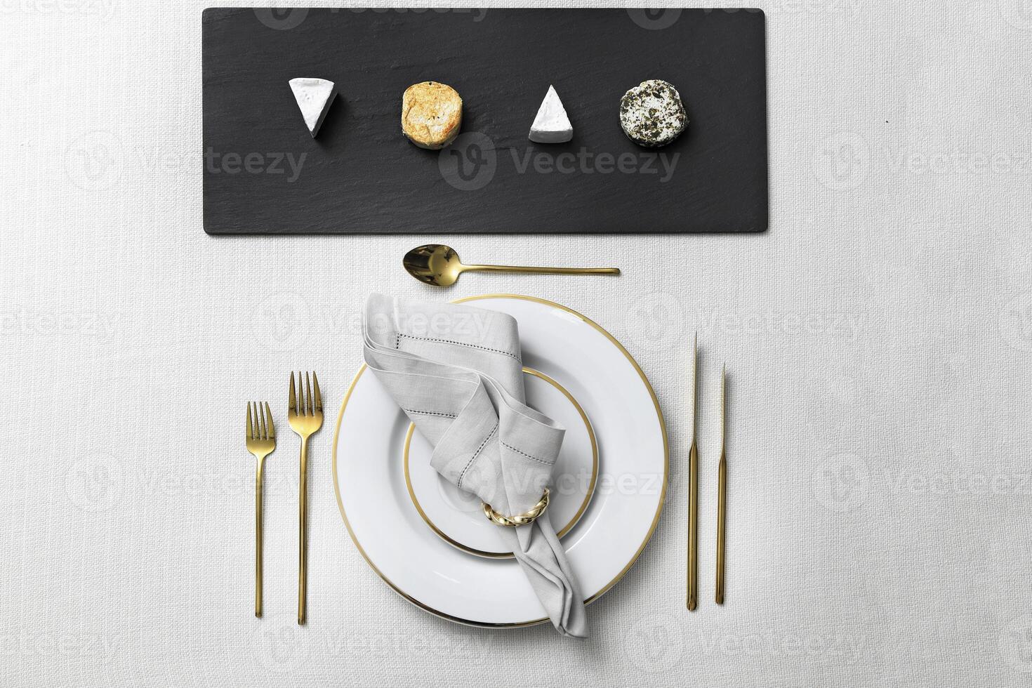 assembly of plates with golden cutlery and various types of cheese photo