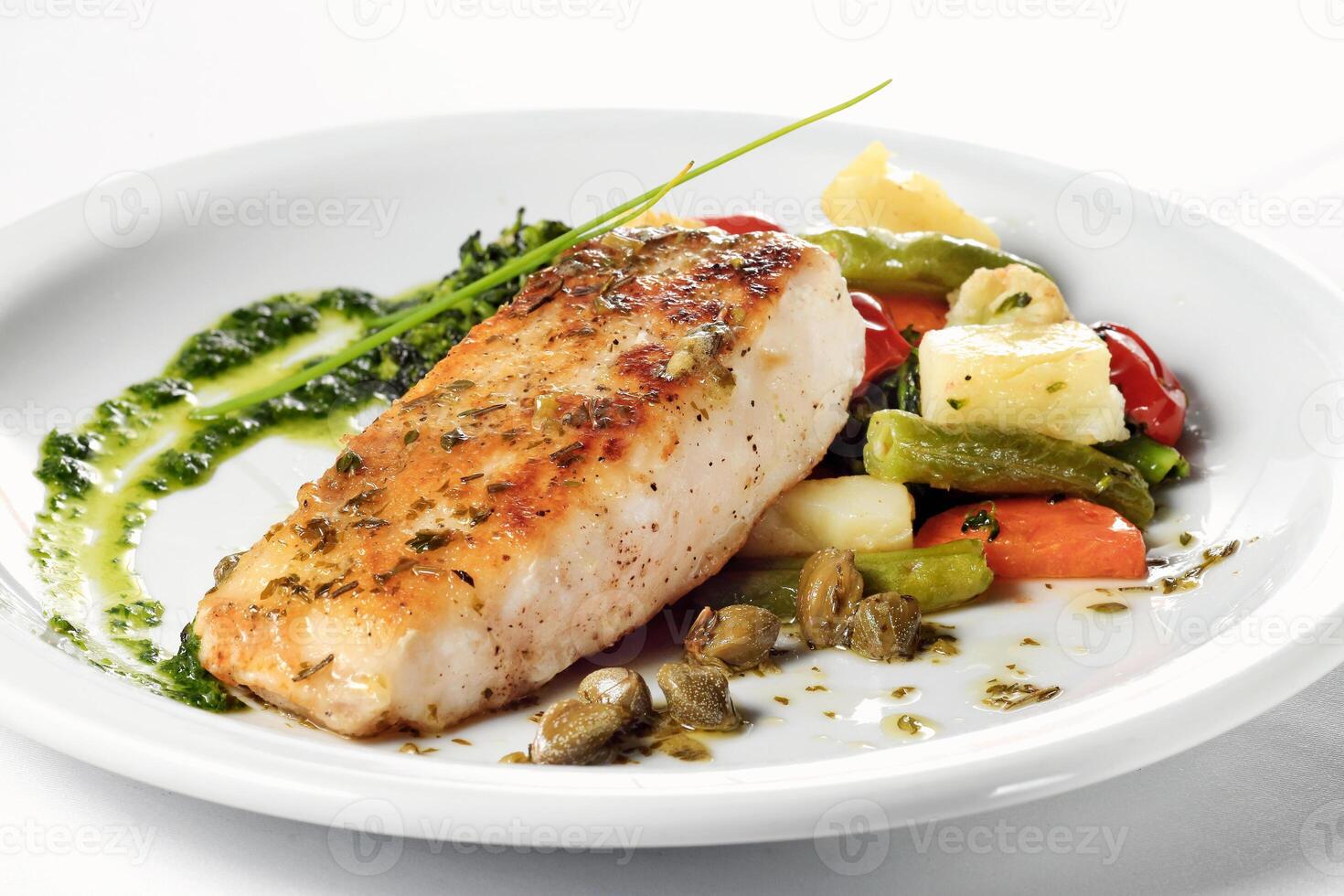 Pirarucu fish fillet with vegetables, broccoli and sauce on plate photo