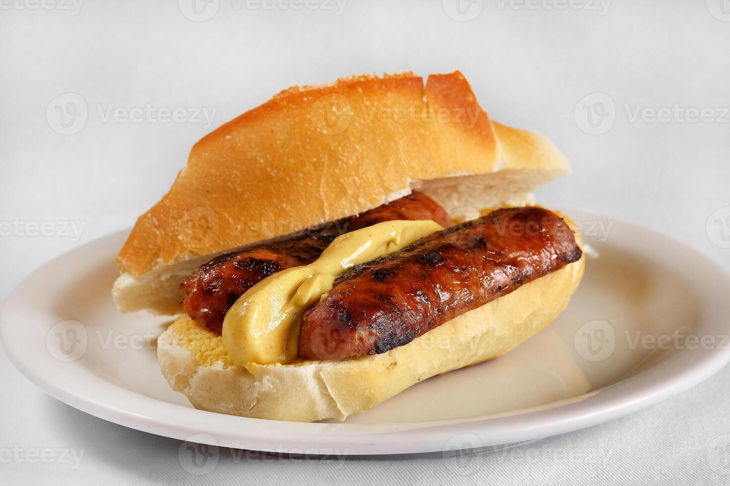 Choripan, Calabrian sausage sandwich with mustard on French bread photo