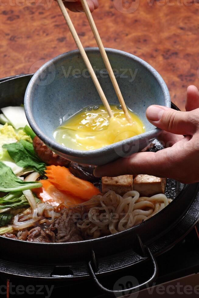 step-by-step guide to Sukiyaki, a classic Japanese dish with vegetables, butter, sauce, meat and tofu cheese photo