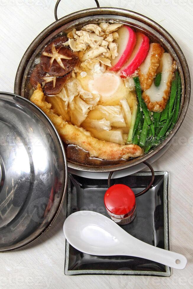 Nabeyaki udon, Japanese soup with cured fish, seaweed, sake, egg and shitake photo
