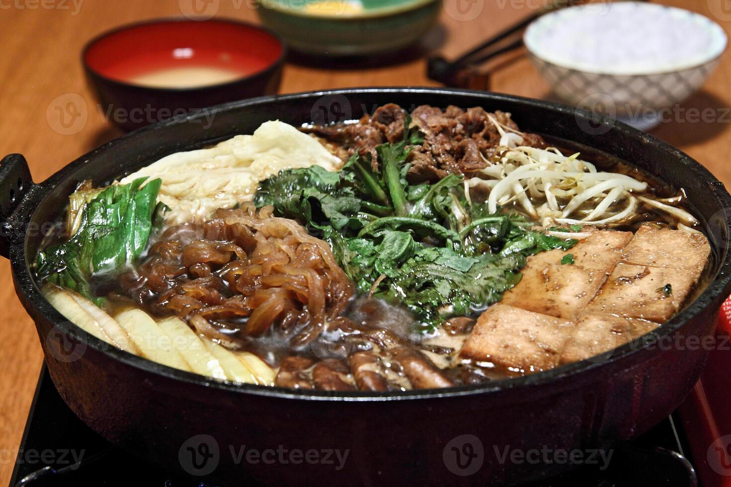 Sukiyaki, Japanese dish with sliced filet, butter, soy sauce, sugar, shitake, chard and tofu photo