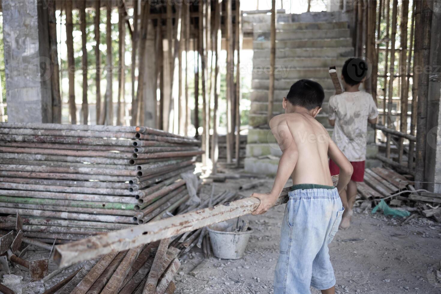 Poor children at the construction site were forced to work. Concept against child labor. The oppression or intimidation of forced labor among children. Human trafficking. photo