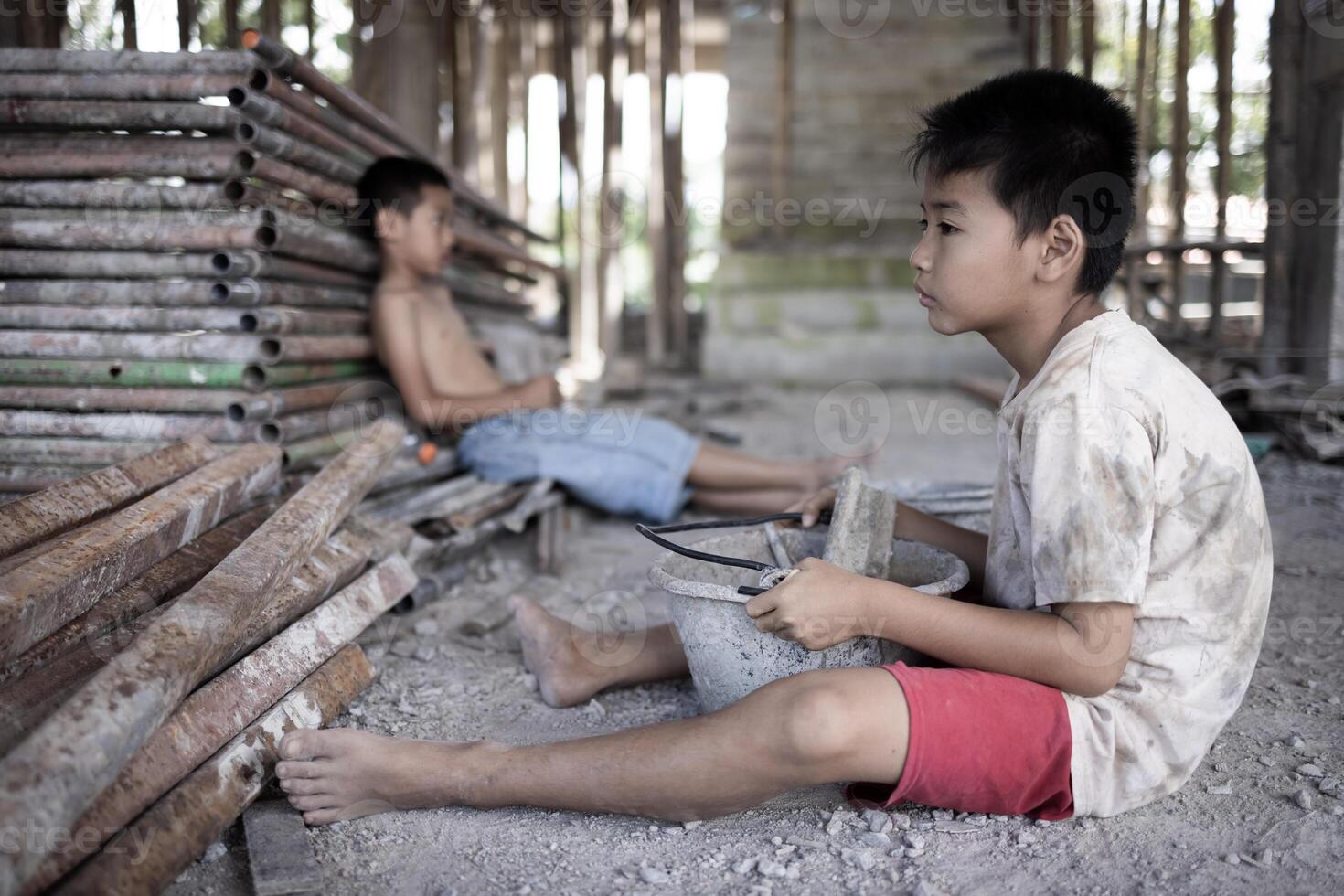 Poor children at the construction site were forced to work. Concept against child labor. The oppression or intimidation of forced labor among children. Human trafficking. photo