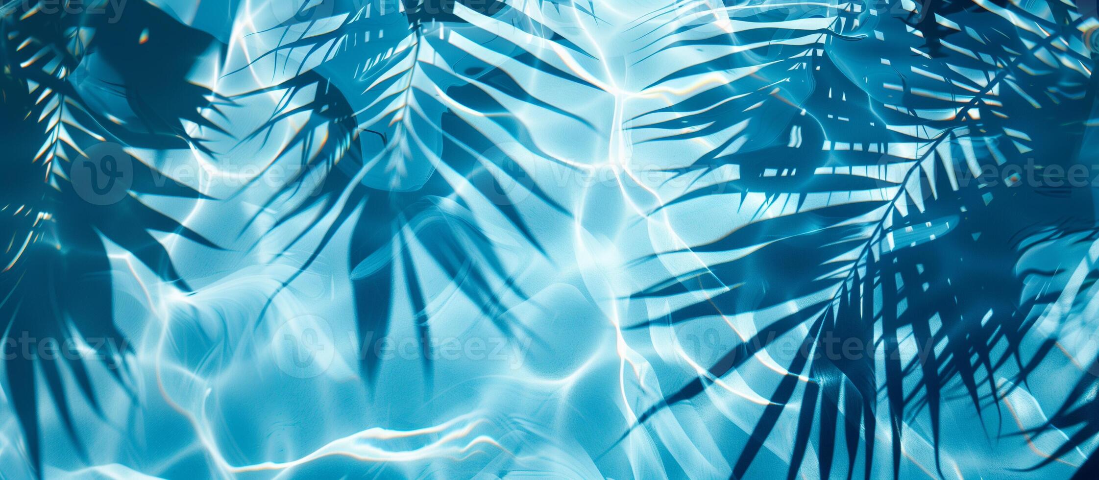A blue ocean with palm trees and their shadows on the water photo