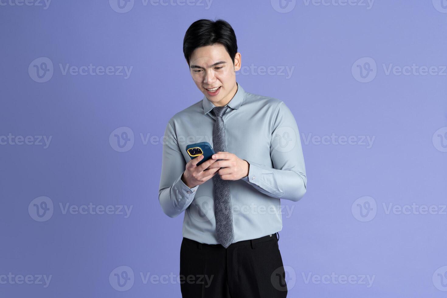 Portrait of Asian male businessman posing on purple background photo