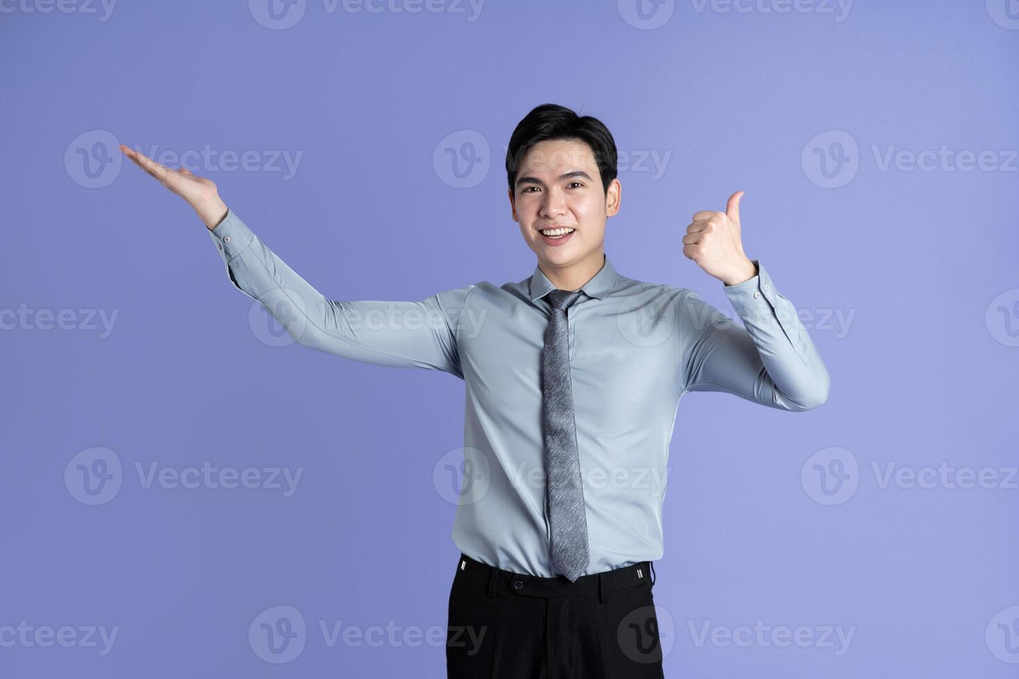 Portrait of Asian male businessman posing on purple background photo