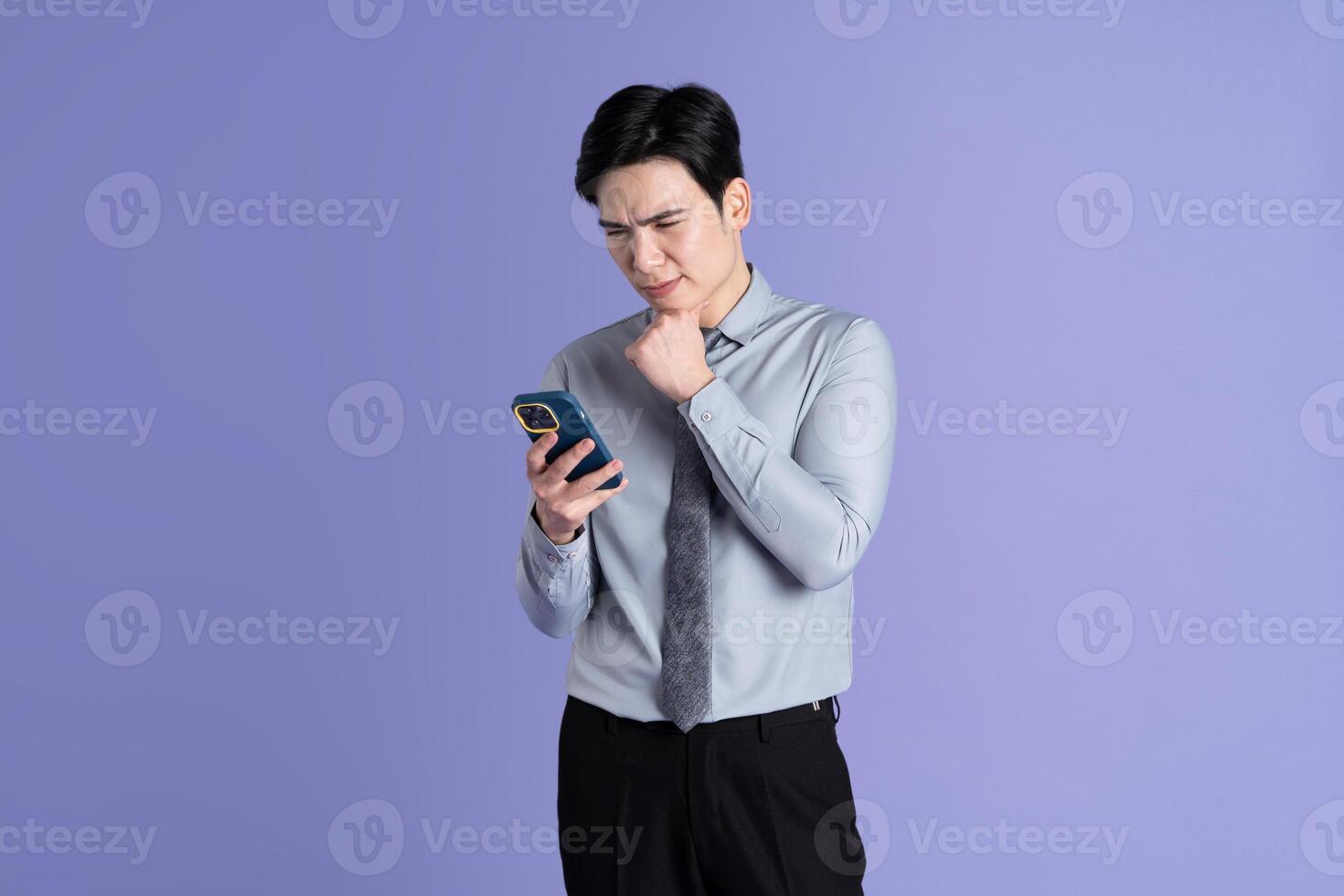 Portrait of Asian male businessman posing on purple background photo