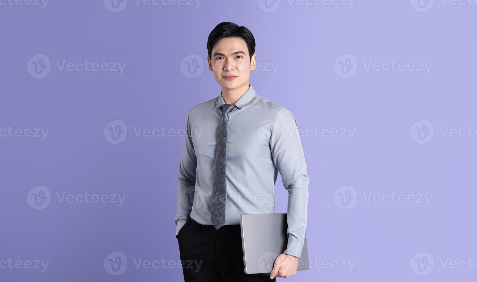 Portrait of Asian male businessman posing on purple background photo