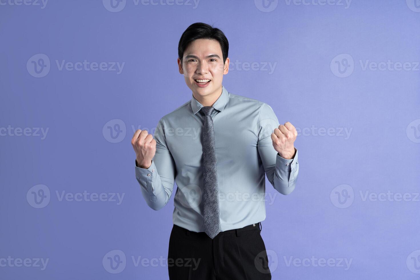 Portrait of Asian male businessman posing on purple background photo