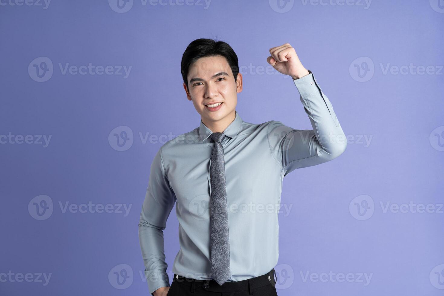Portrait of Asian male businessman posing on purple background photo