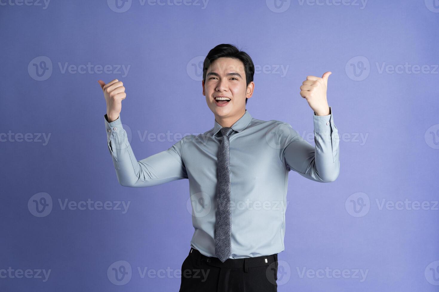 Portrait of Asian male businessman posing on purple background photo