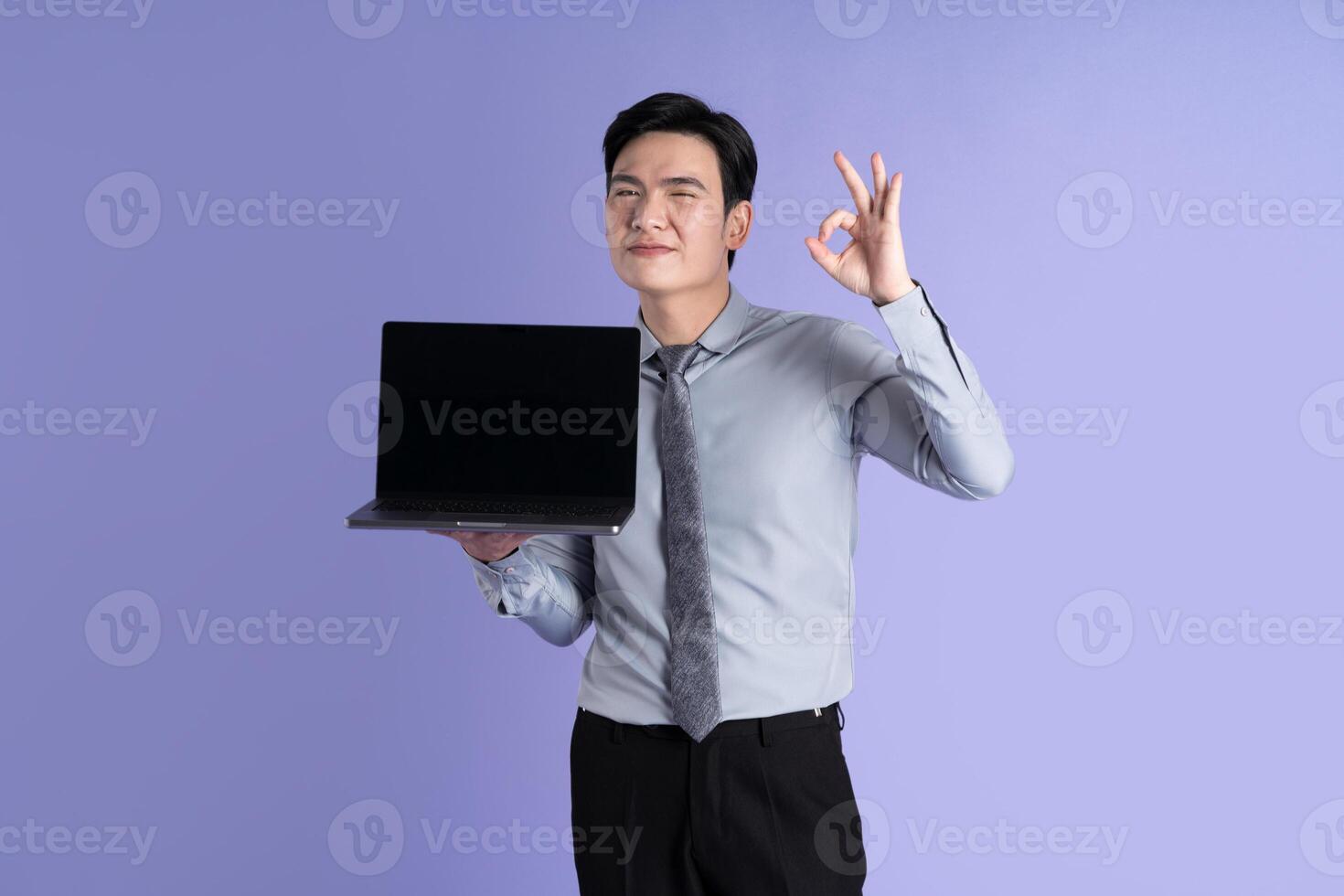 retrato de asiático masculino empresario posando en púrpura antecedentes foto