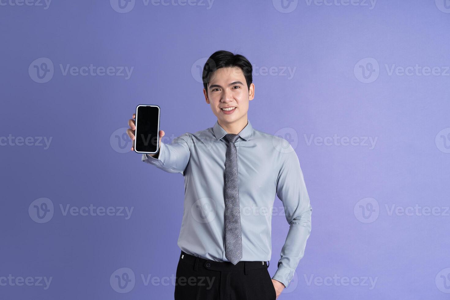 Portrait of Asian male businessman posing on purple background photo