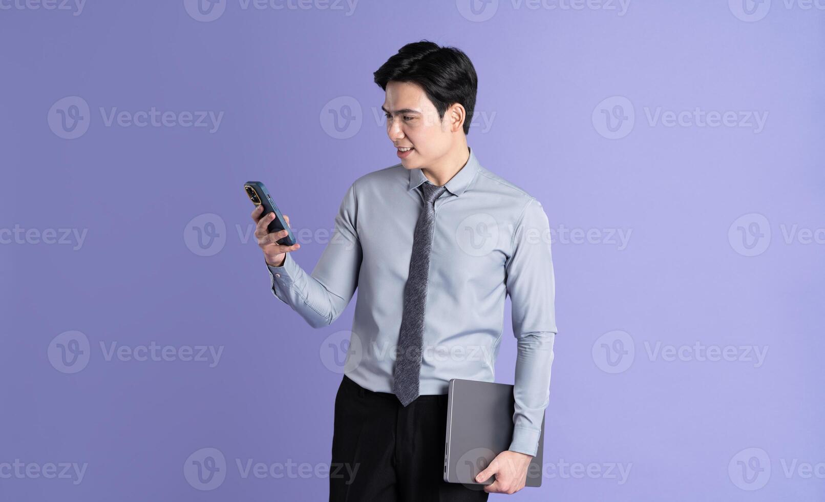 Portrait of Asian male businessman posing on purple background photo