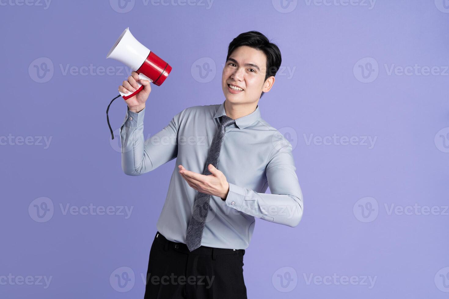 Portrait of Asian male businessman posing on purple background photo