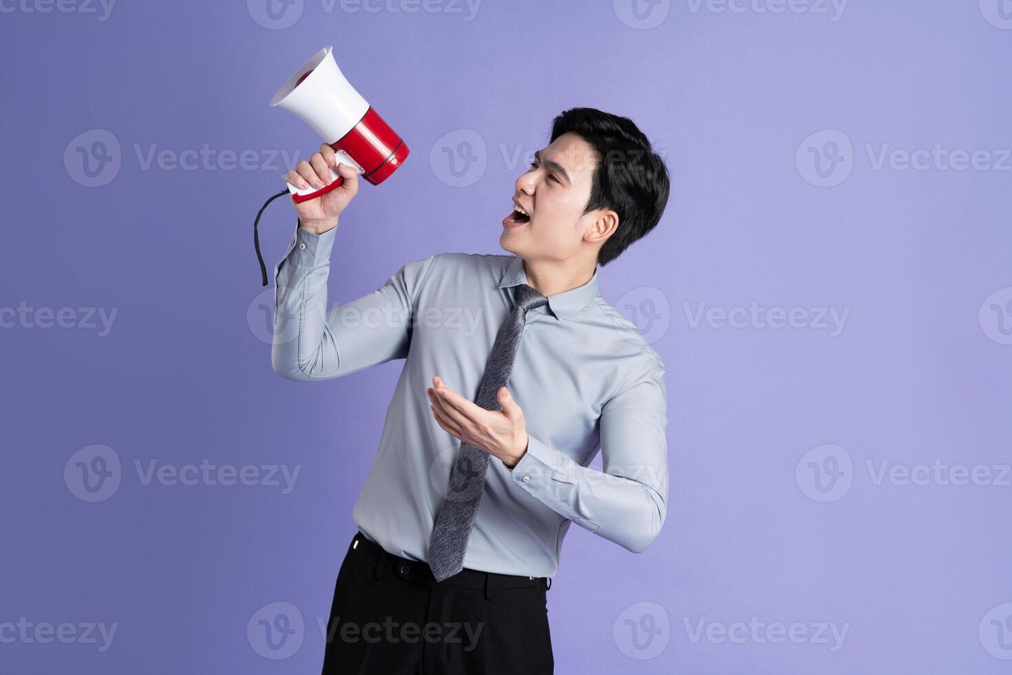 Portrait of Asian male businessman posing on purple background photo