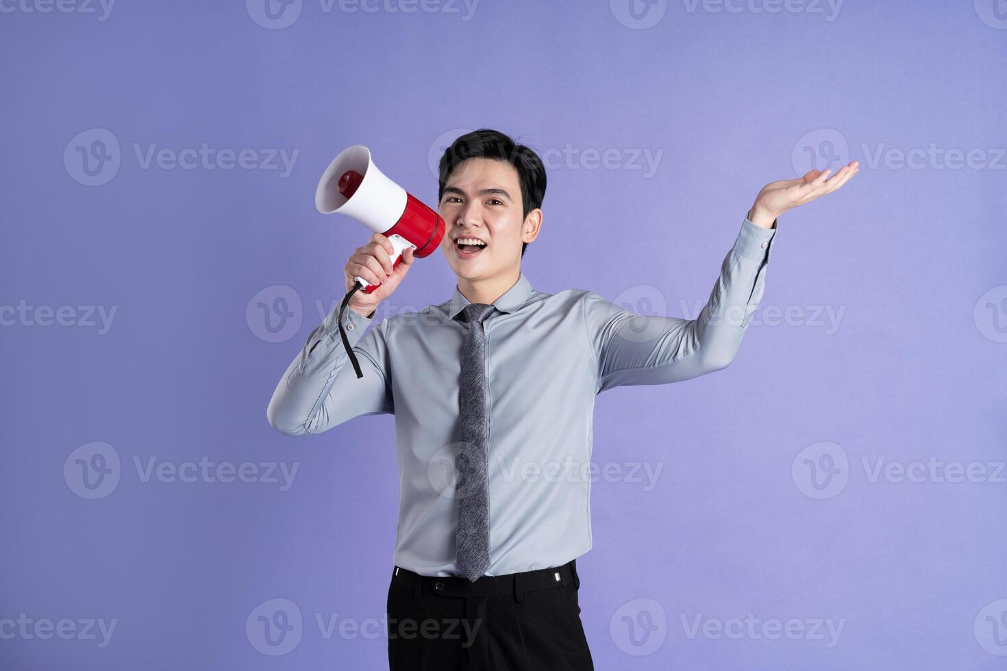 Portrait of Asian male businessman posing on purple background photo