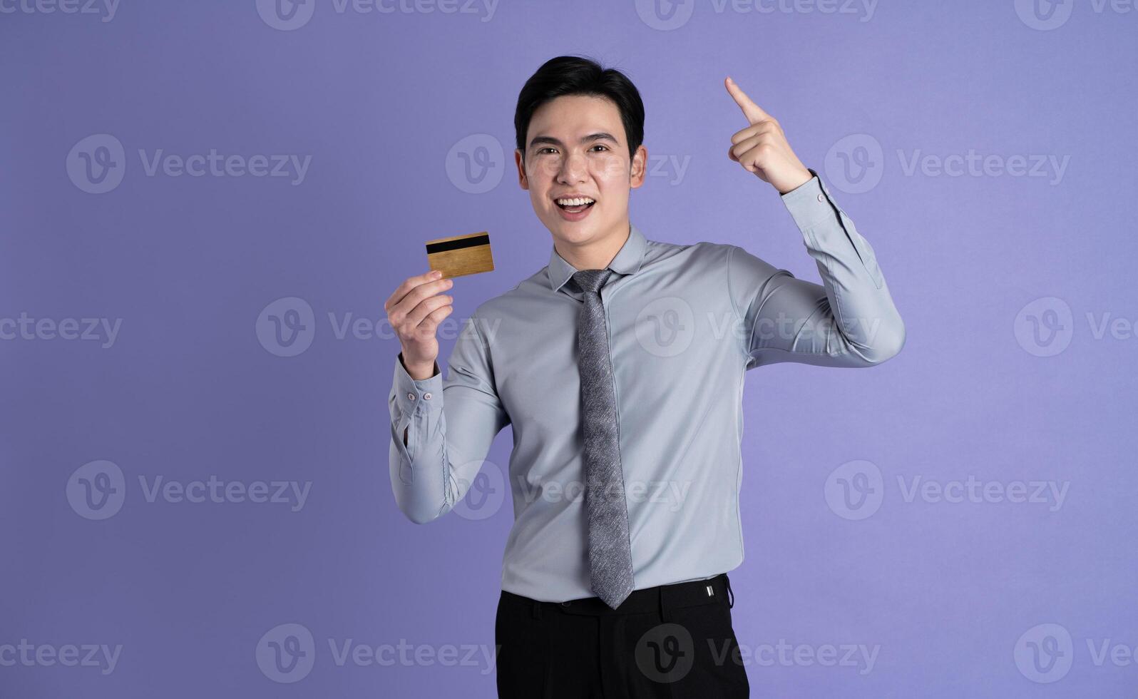 Portrait of Asian male businessman posing on purple background photo