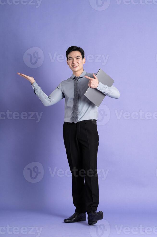 retrato de asiático masculino empresario en pie y posando en púrpura antecedentes foto