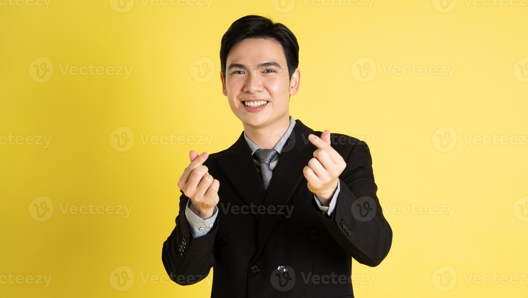 Portrait of Asian male businessman. wearing a suit and posing on a yellow background photo