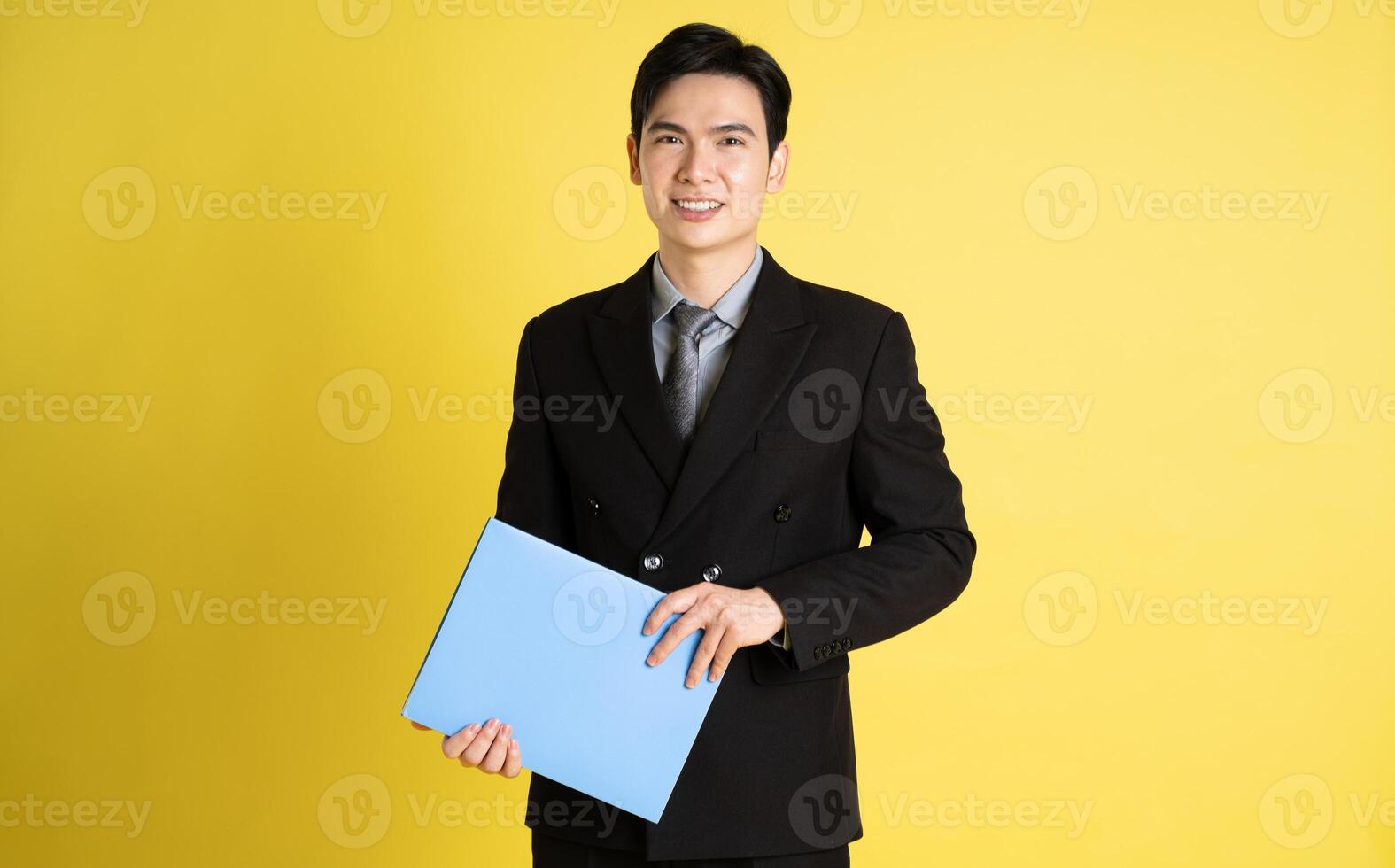 retrato de asiático masculino empresario. vistiendo un traje y posando en un amarillo antecedentes foto