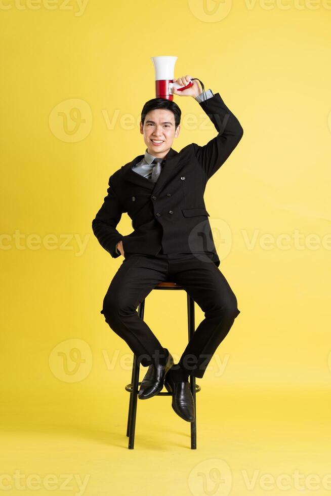 retrato de asiático masculino empresario. vistiendo un traje y posando en un amarillo antecedentes foto