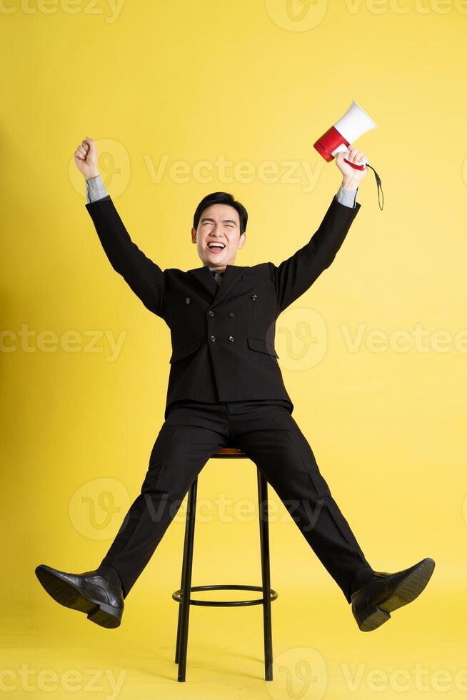 retrato de asiático masculino empresario. vistiendo un traje y posando en un amarillo antecedentes foto