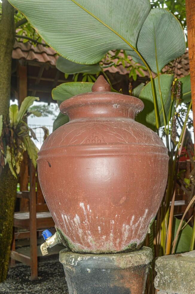 un jarra con un grifo para Lavado manos en un tradicional javanés restaurante foto