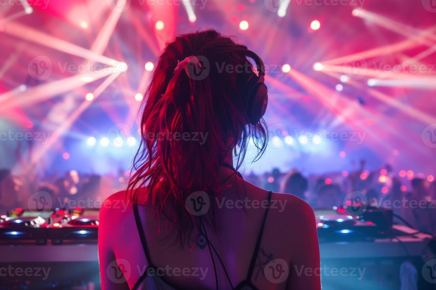 Female DJ on a big rave playing for a big crowd of party people, ravers dancing, big laser show photo