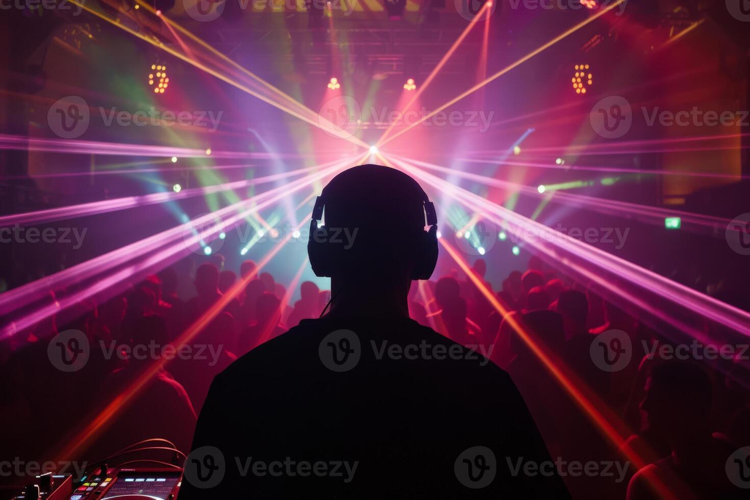 Male DJ on a big rave playing for a big crowd of party people, ravers dancing, big laser show photo