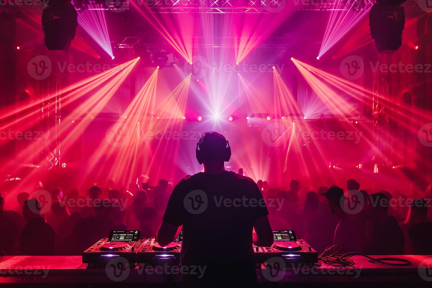 Male DJ on a big rave playing for a big crowd of party people, ravers dancing, big laser show photo