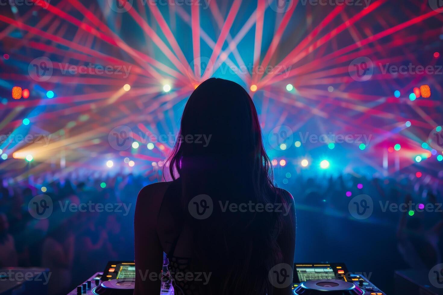 Female DJ on a big rave playing for a big crowd of party people, ravers dancing, big laser show photo