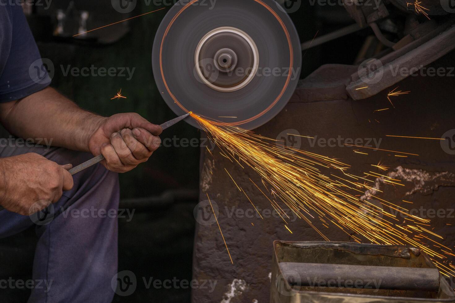 Industrial worker with angle grinder cutting metal with many sharp sparks on workplace photo