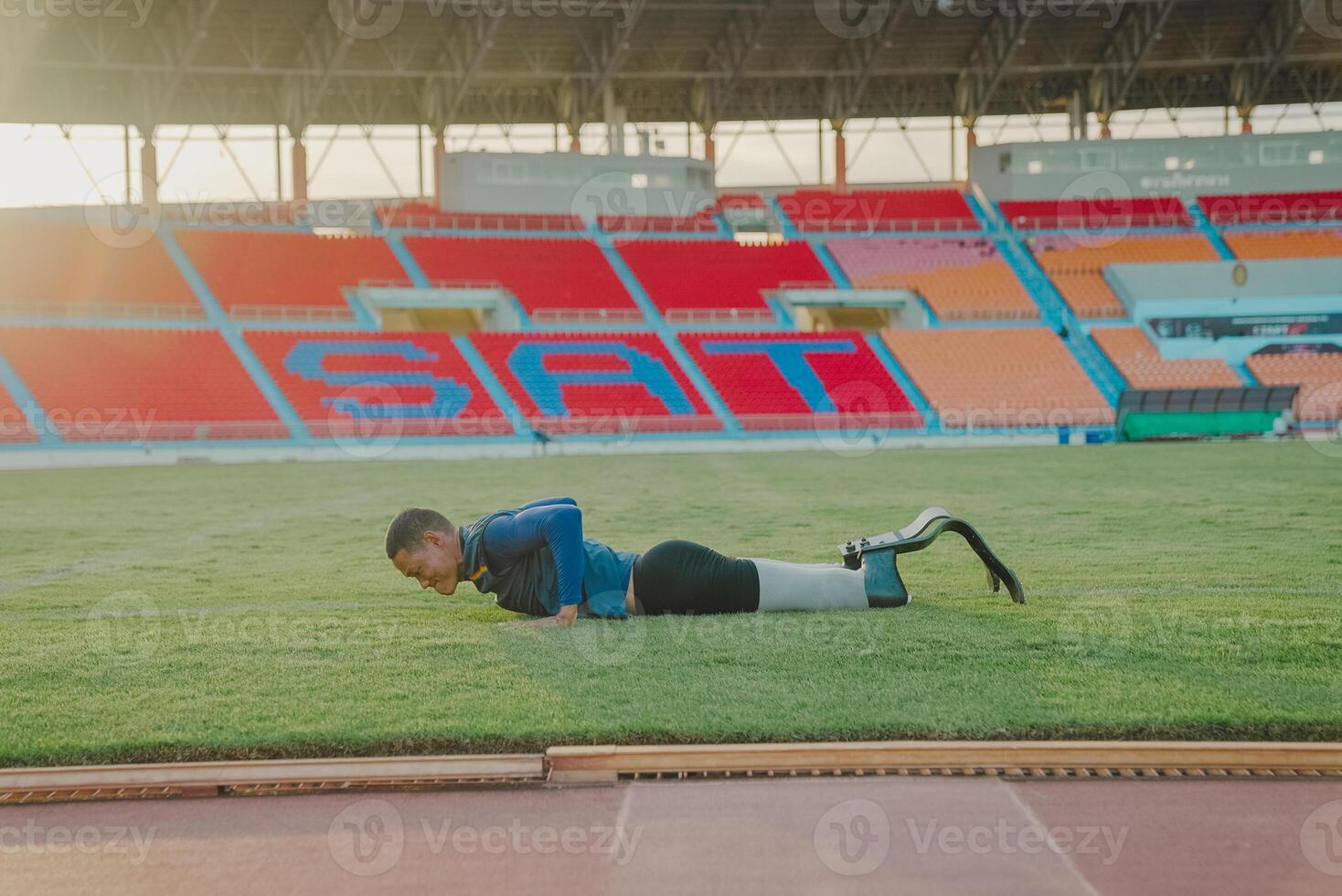 Asian para-athlete runner prosthetic leg on the track alone outside on a stadium track Paralympic running concept. photo