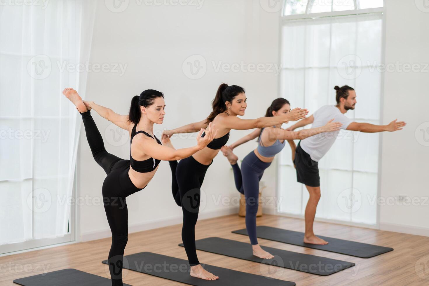 un yoga profesor y su grupo de estudiantes hacer básico yoga poses en un salón de clases en un aptitud centrar en el estudio. foto
