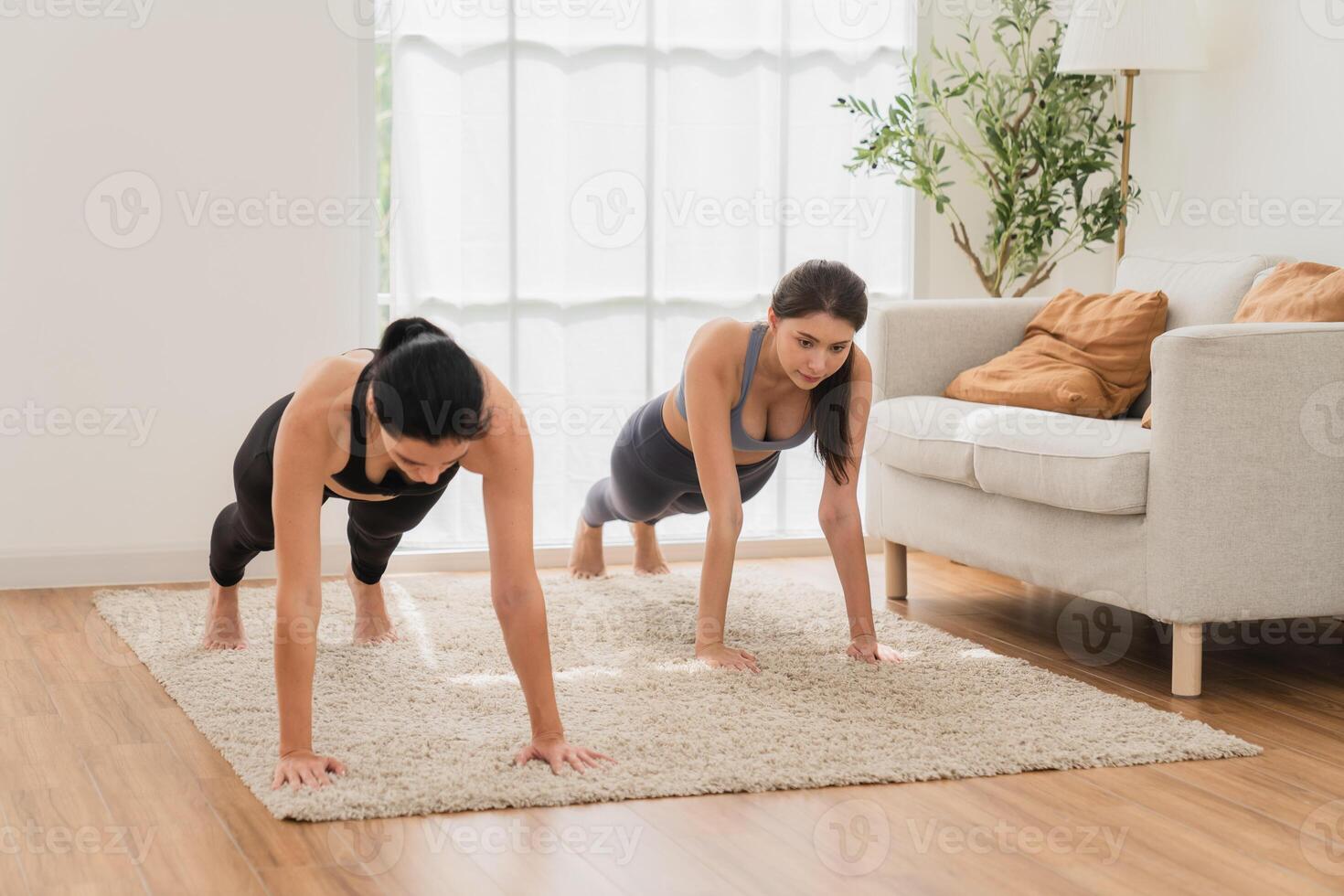 A young fit woman practices yoga by doing asanas in a bright yoga studio. Yoga practitioner with students in yoga class. photo