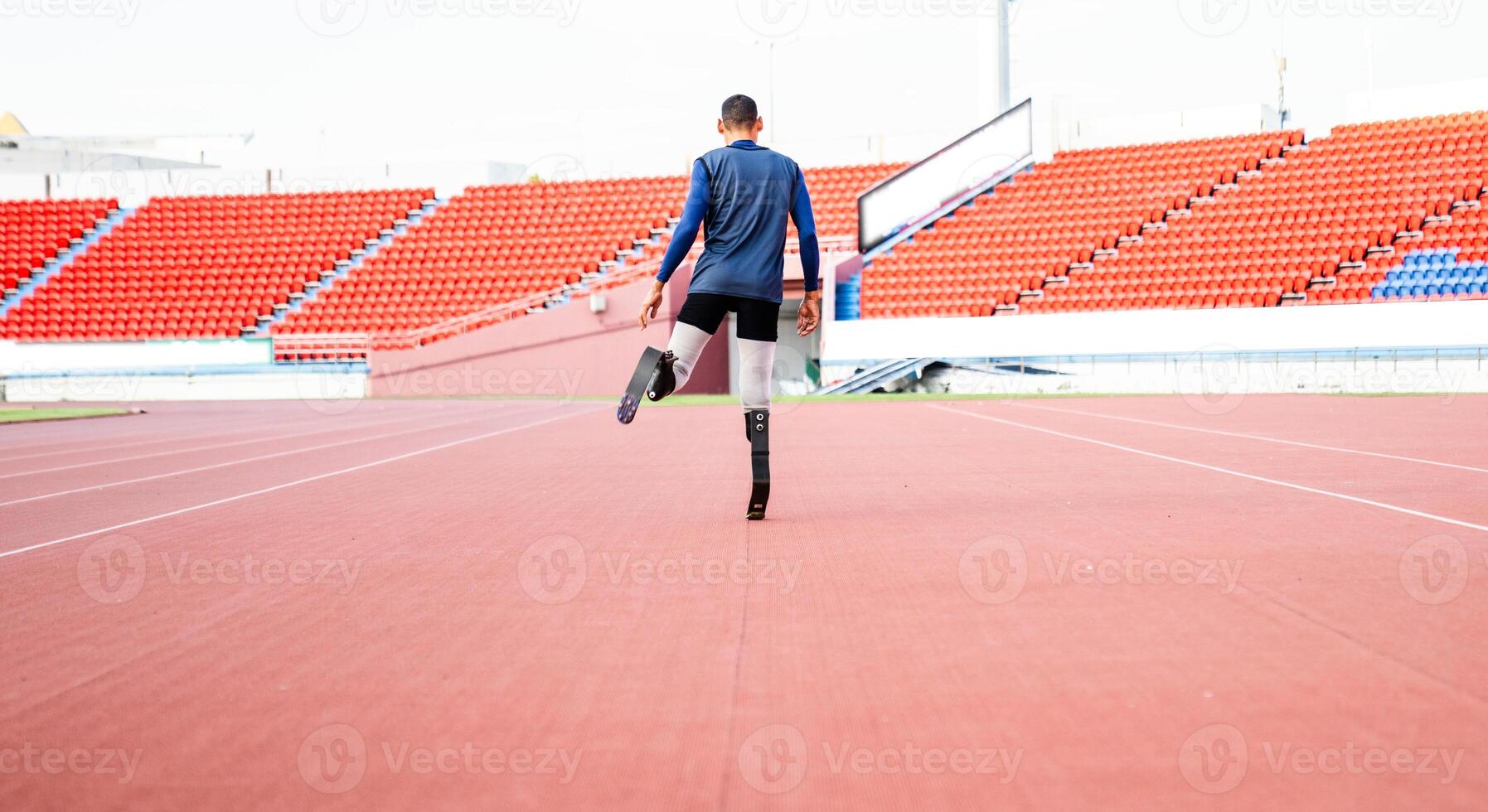 Asian para-athlete runner prosthetic leg on the track alone outside on a stadium track Paralympic running concept. photo