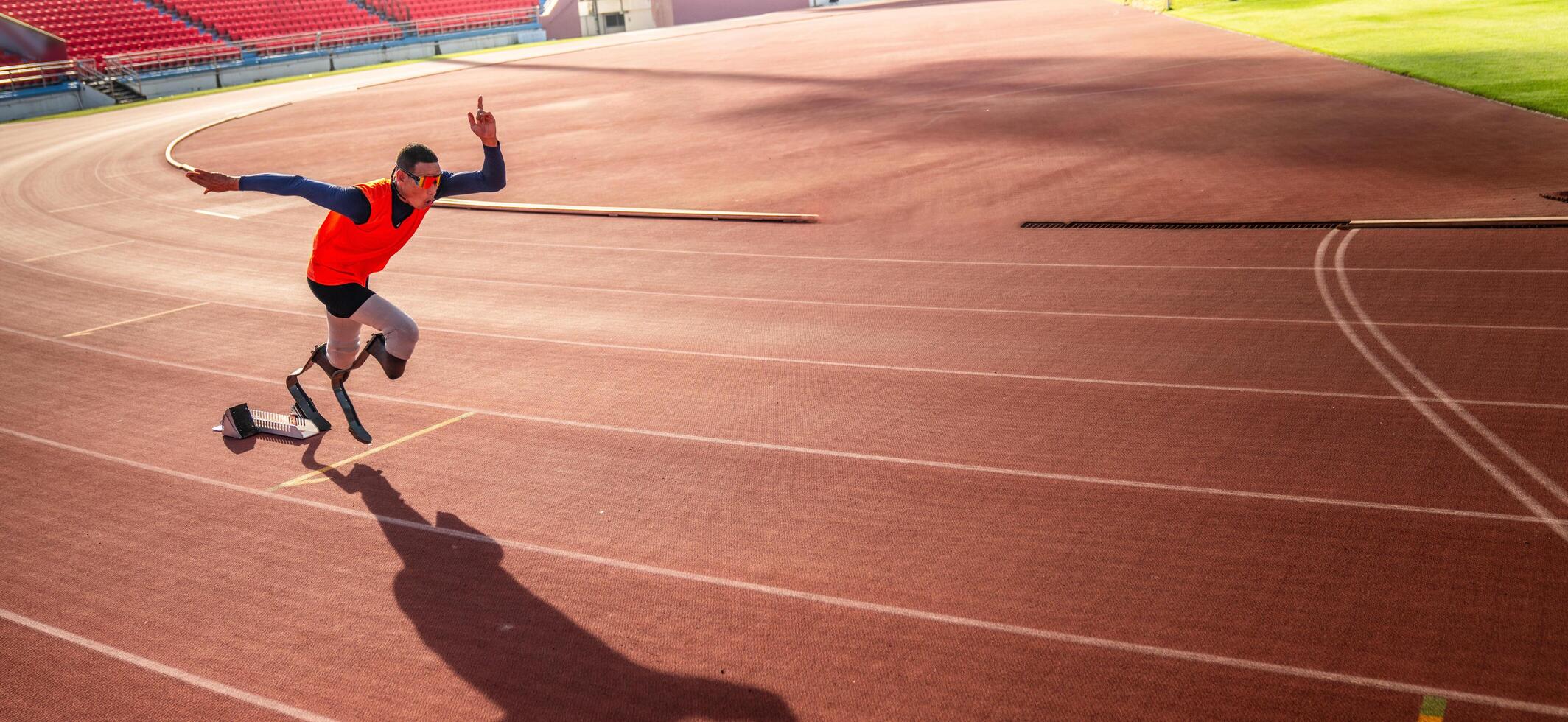 asiático para-atleta corredor protésico pierna en el pista solo fuera de en un estadio pista paralímpico corriendo concepto. foto