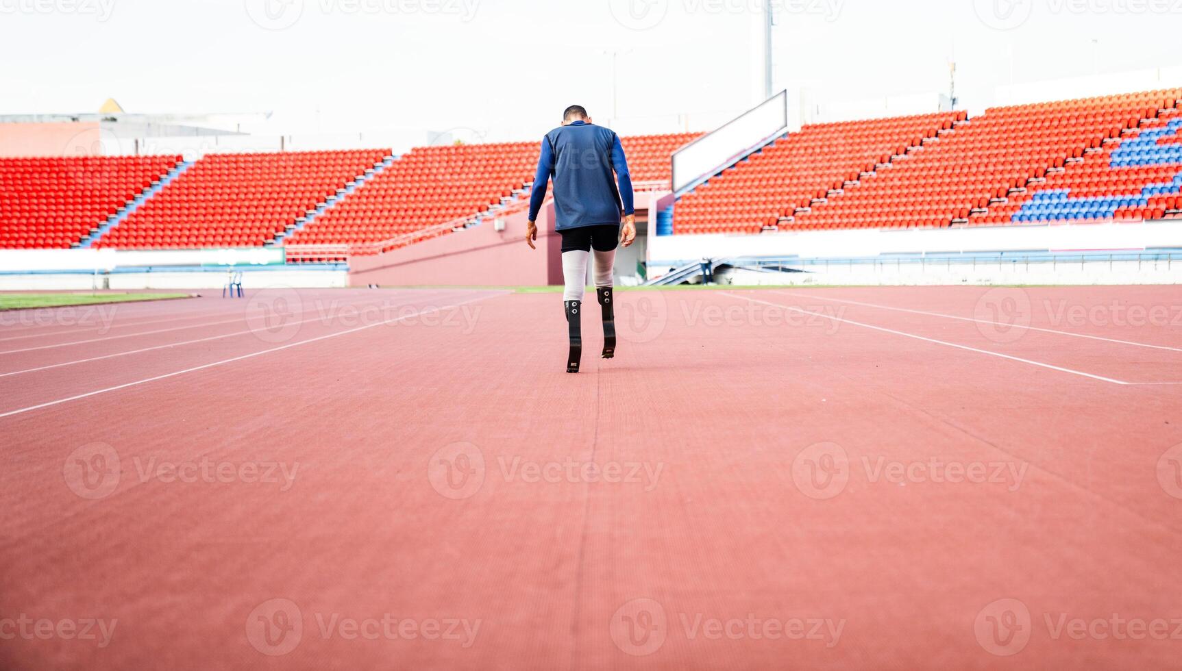 Asian para-athlete runner prosthetic leg on the track alone outside on a stadium track Paralympic running concept. photo